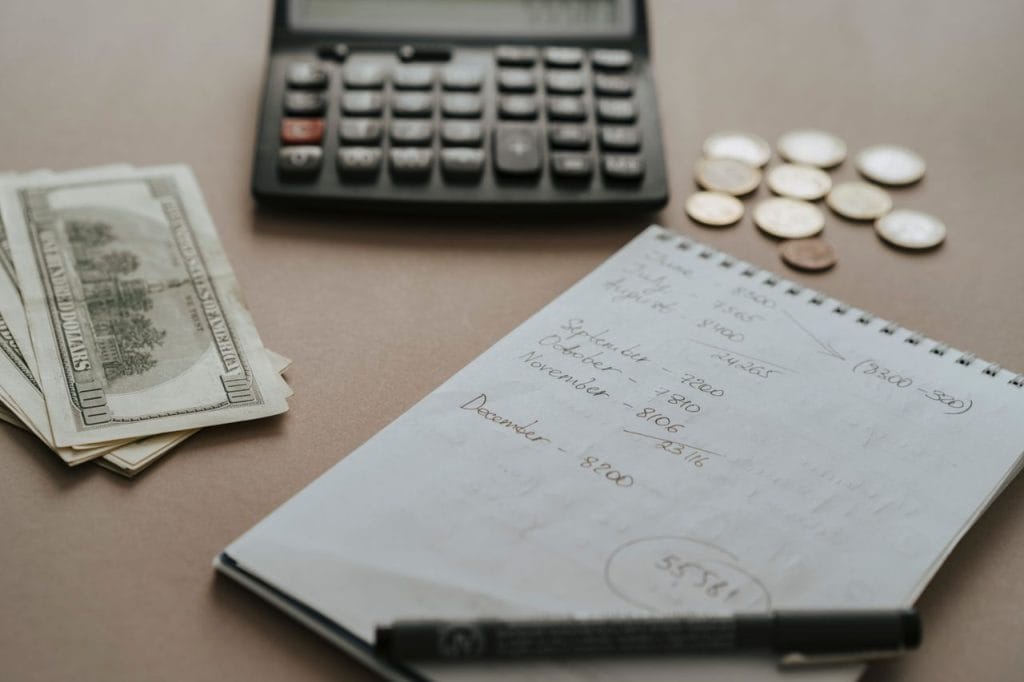 Paiement en espèces : calculatrice, billets et pièces sur un bureau